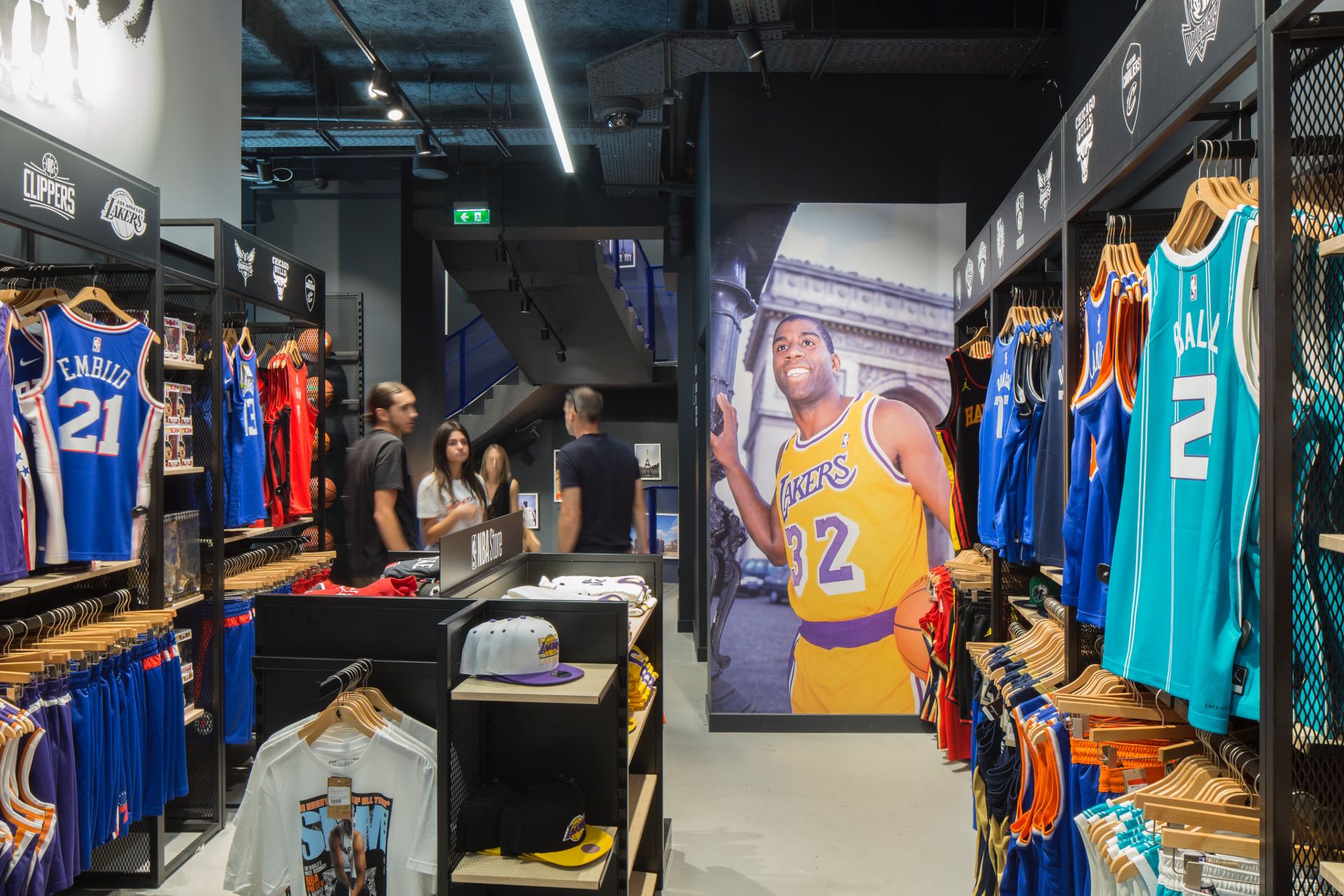 Intérieur du magasin NBA avec ses clients et une affiche de basketteur