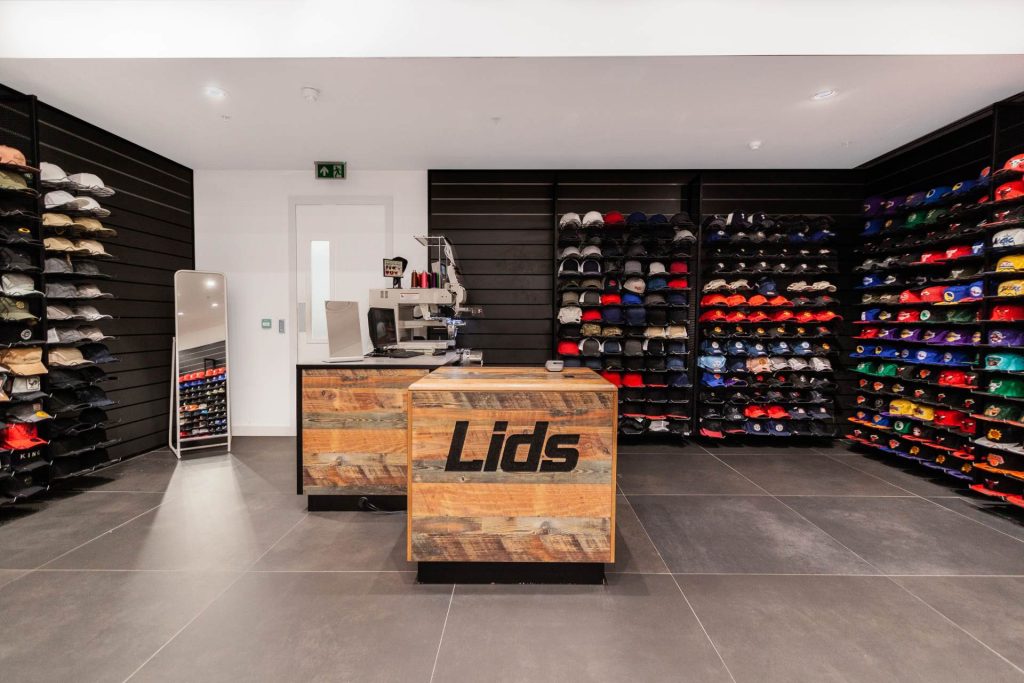 Mur noir, rangement, sol gris, commode en bois clair avec logo