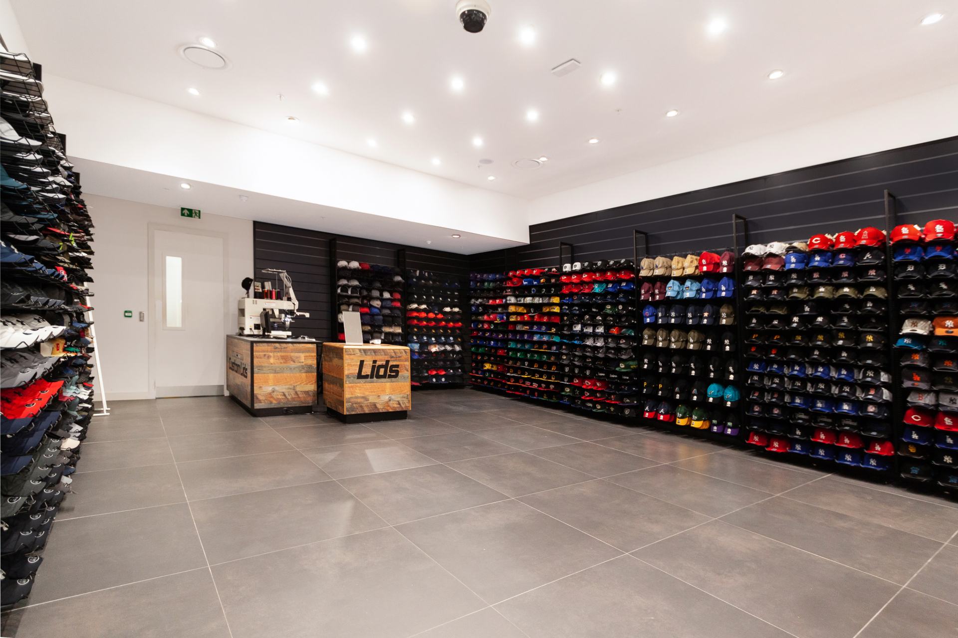 Mur noir, rangement, sol gris, commode en bois clair avec logo