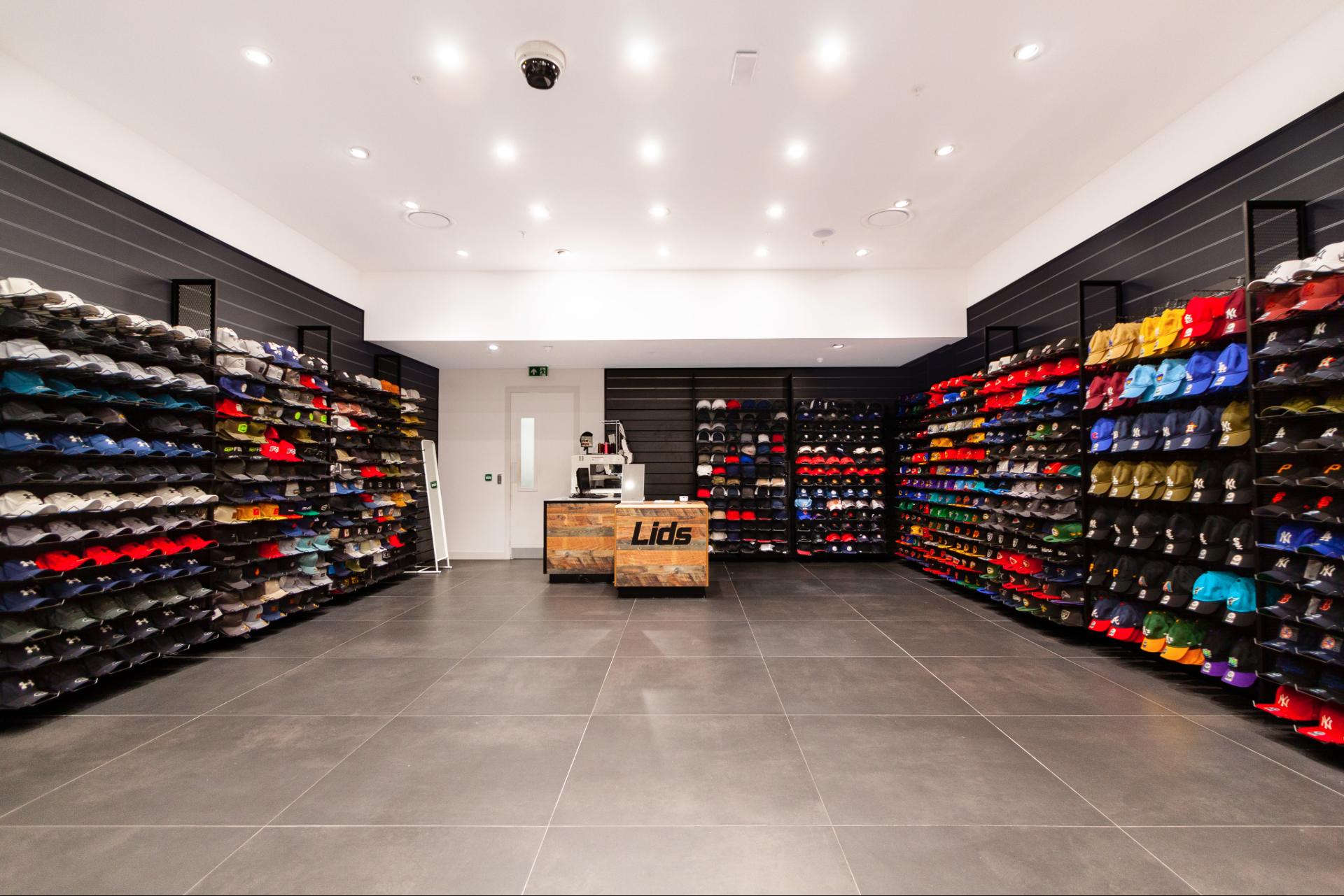 Mur noir, rangement, sol gris, commode en bois clair avec logo