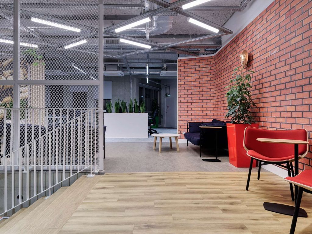 Parquet en bois clair, mur de brique rouge, escalier en métal