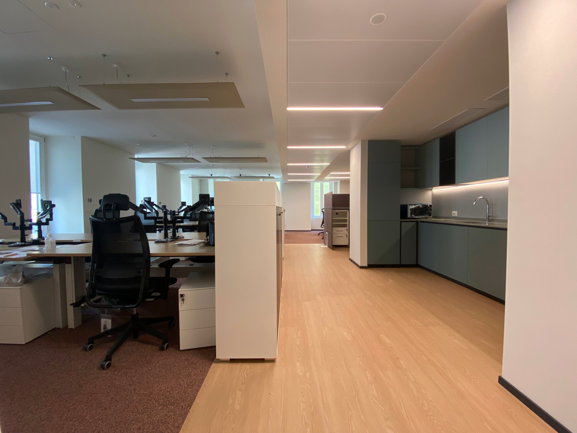 Coworking, parquet bois clair, moquette rouge, meuble blanc