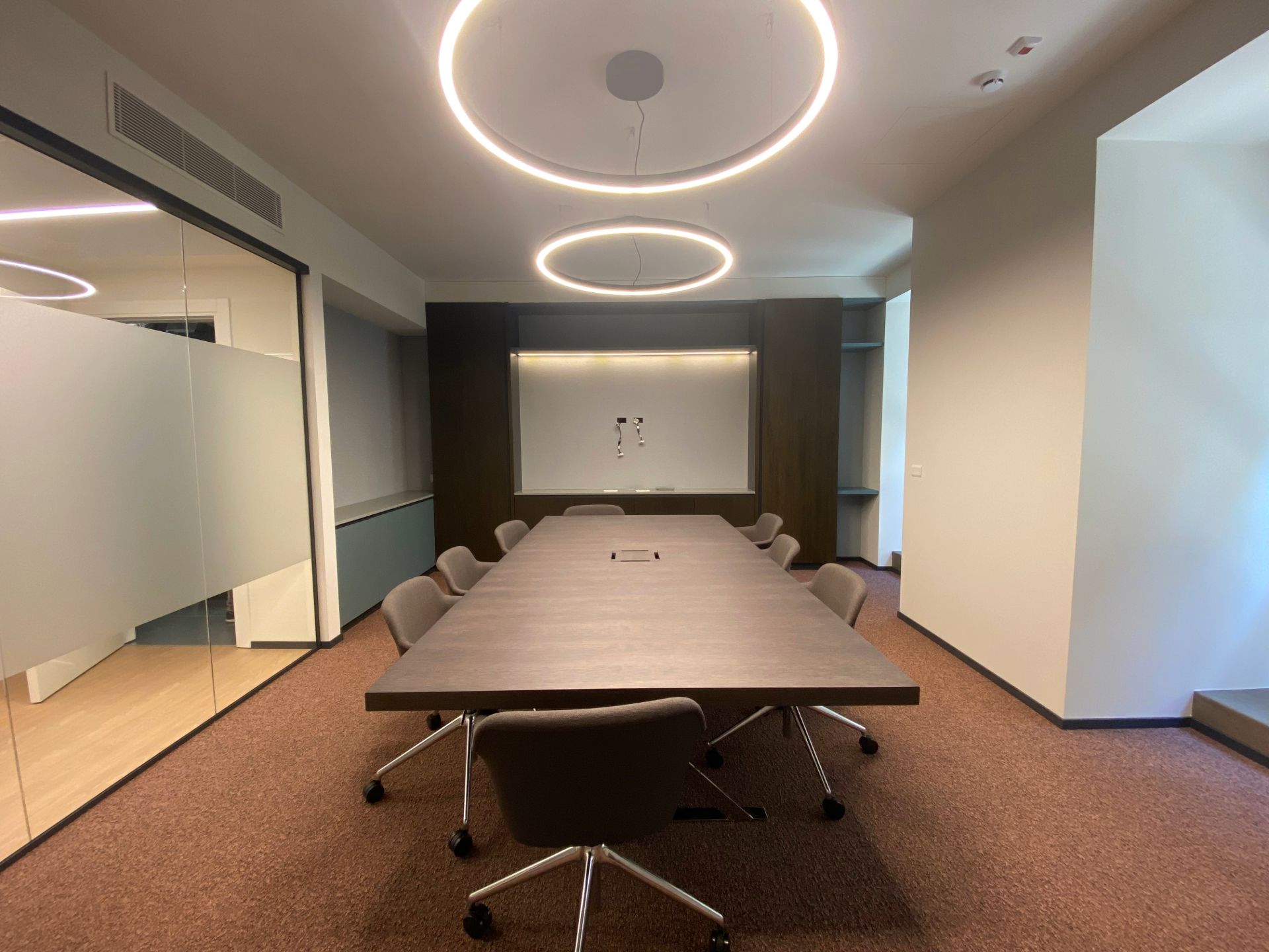 Salle de réunion, moquette rouge foncé, table noire