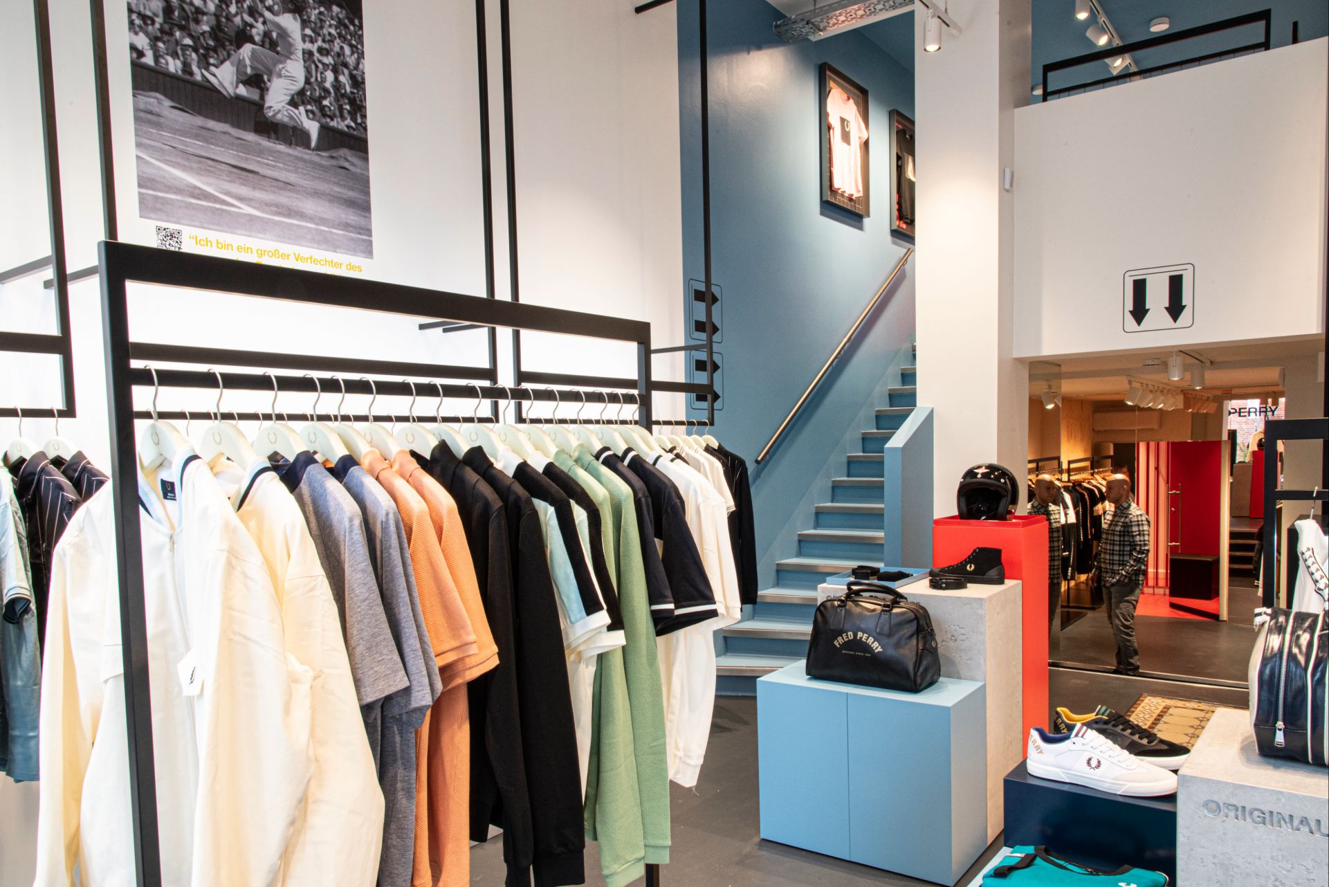 Intérieur de la boutique, sol gris en lino, portant noir métallique, mur bleu et blanc