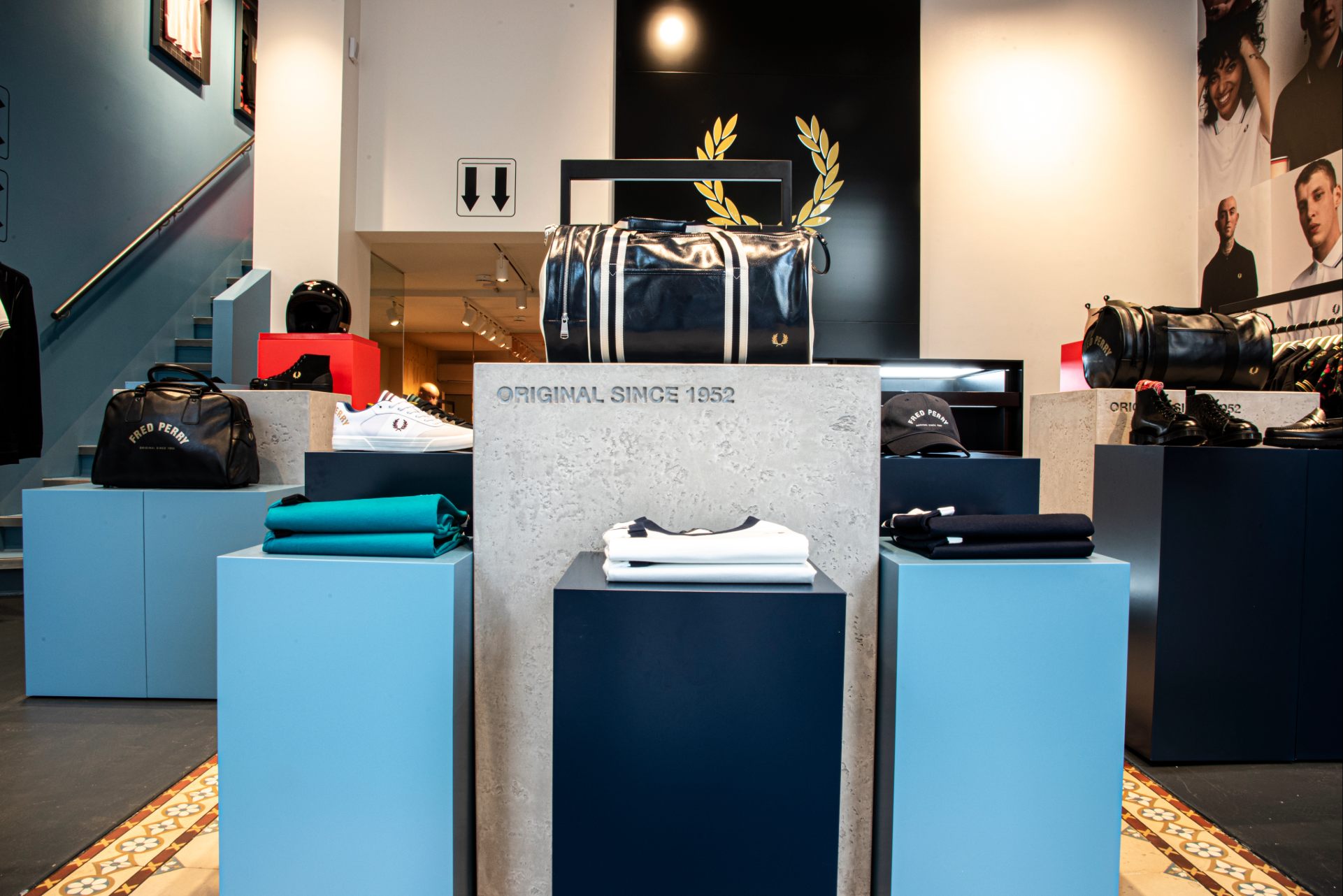 Intérieur de la boutique, sol gris en lino, portant noir métallique, mur bleu et blanc