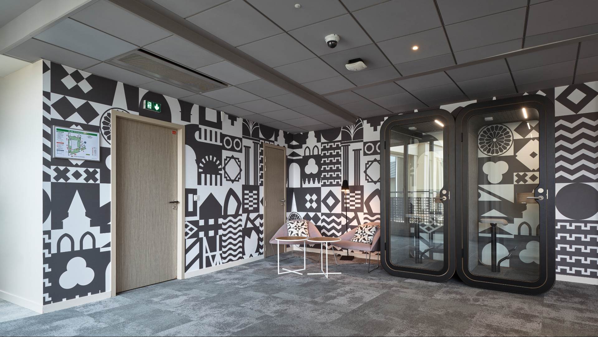 Grande pièce avec décoration murale noire et blanche , bulles de réunion isolées noires, fauteuil rose, porte en bois clair