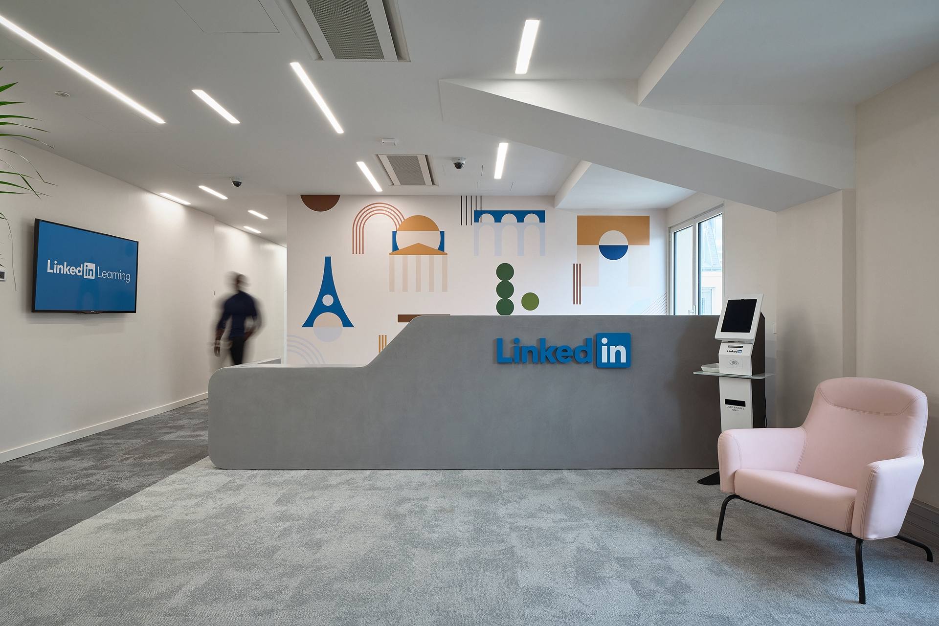 Salle d'attente des bureaux Linkedin, moquette grise, fauteuil rose