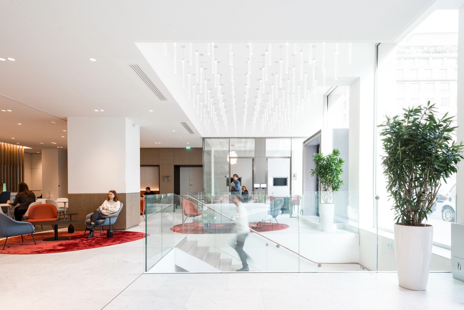 Etage chez Unofi, avec escalier central permettant de descendre à l'étage inférieur, espace très lumineux, luminaire décoratif au plafond au dessus de l'escalier