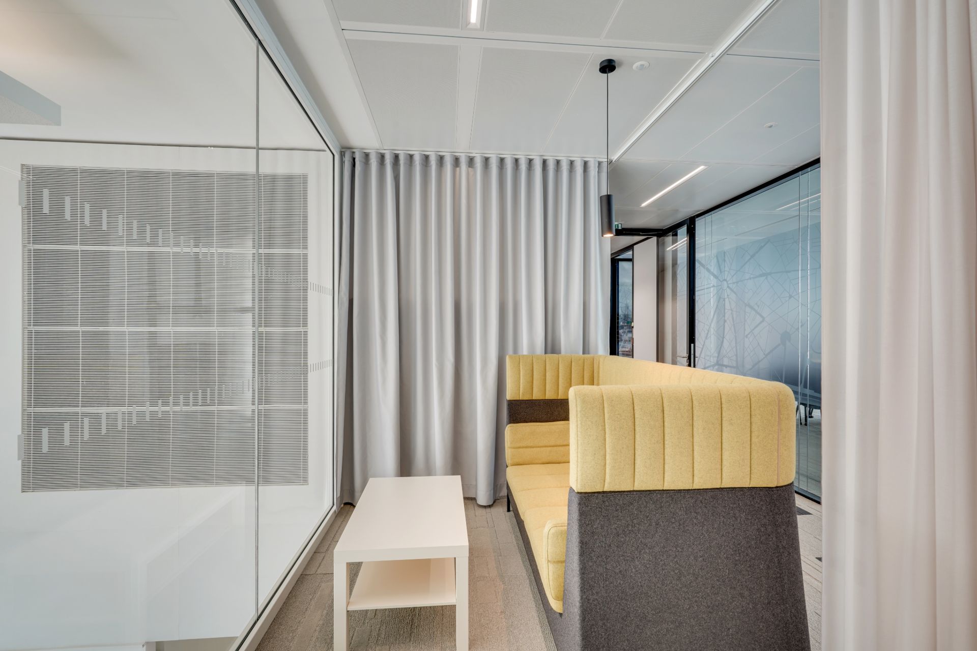 Espace de réunion ou de pause, banquette jaune pâle avec table basse blanche