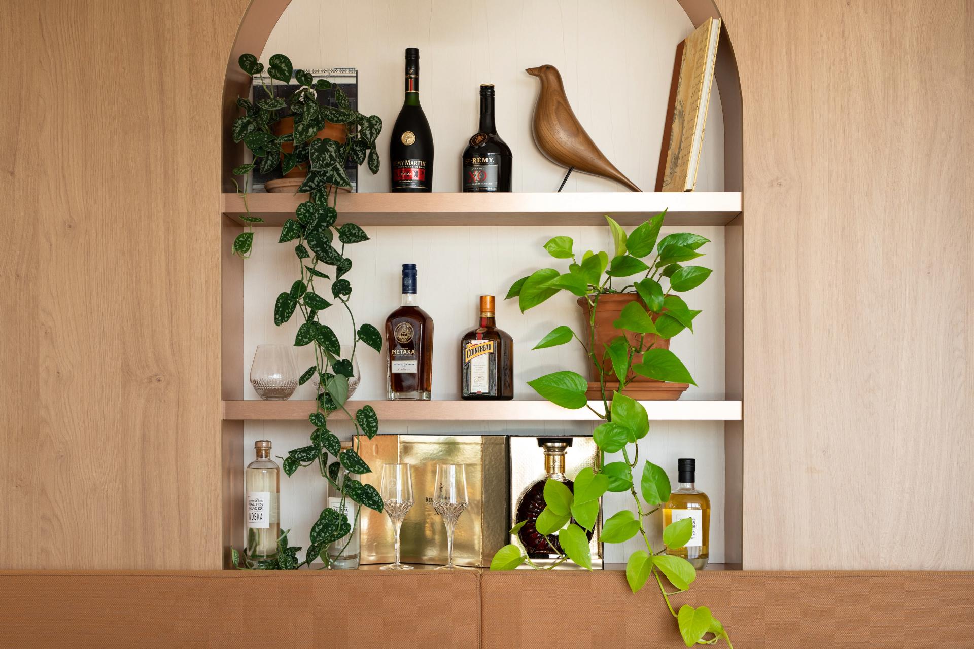 Etagère décorative avec des bouteilles de la marque, plantes décoratives etc.