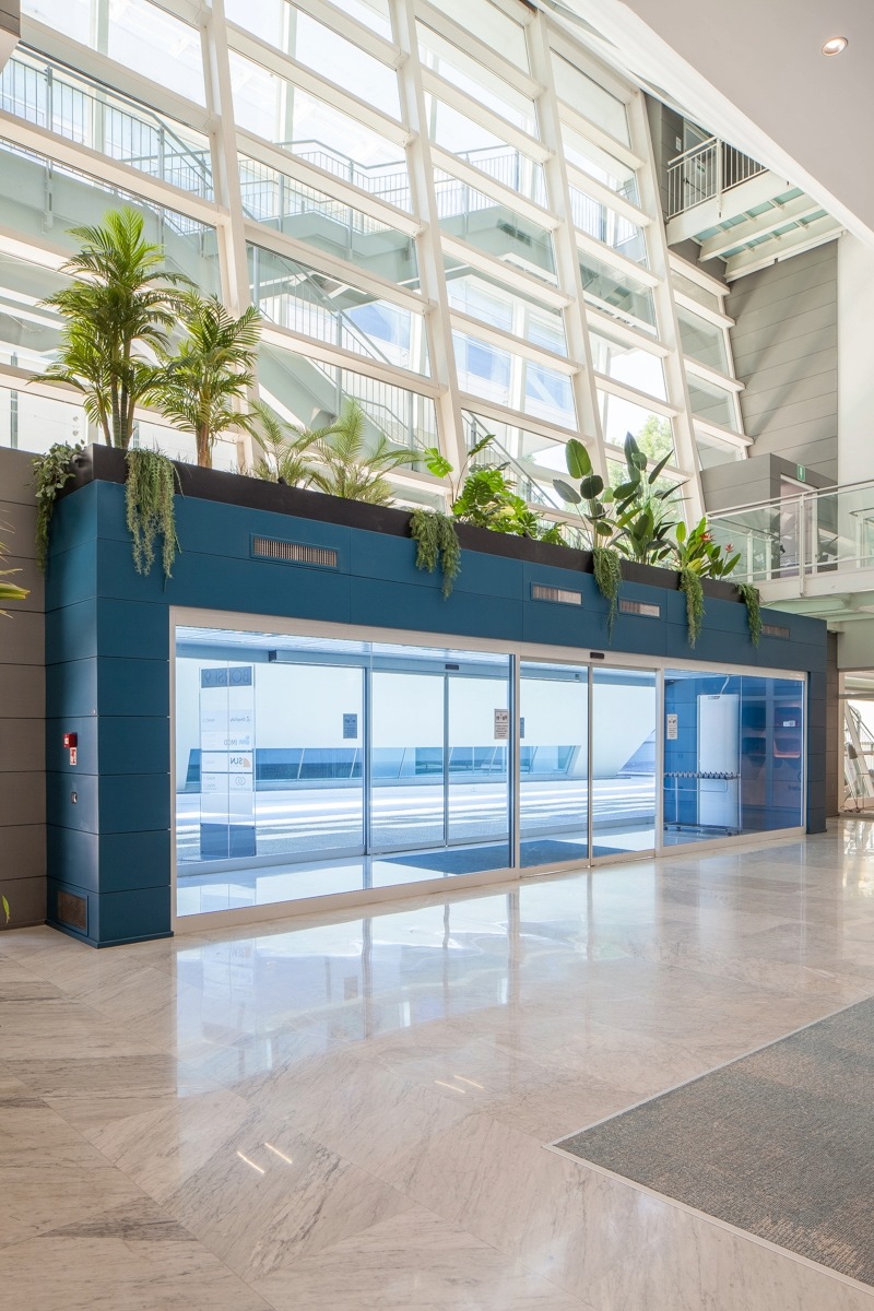 Entrée du bâtiment vu de l'intérieur, le tour est couleur bleu canard et des plantes ont été mise au dessus