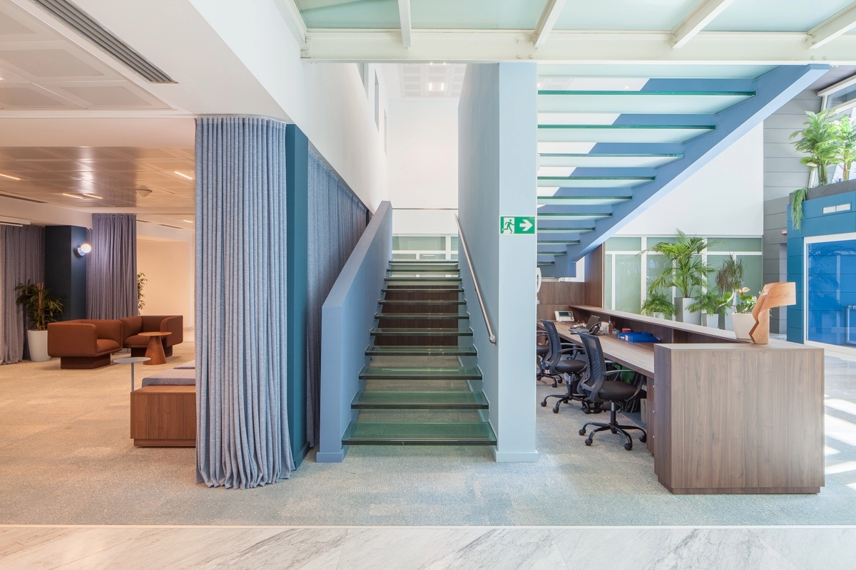 Hall d'accueil avec escalier bleu menant à l'étage