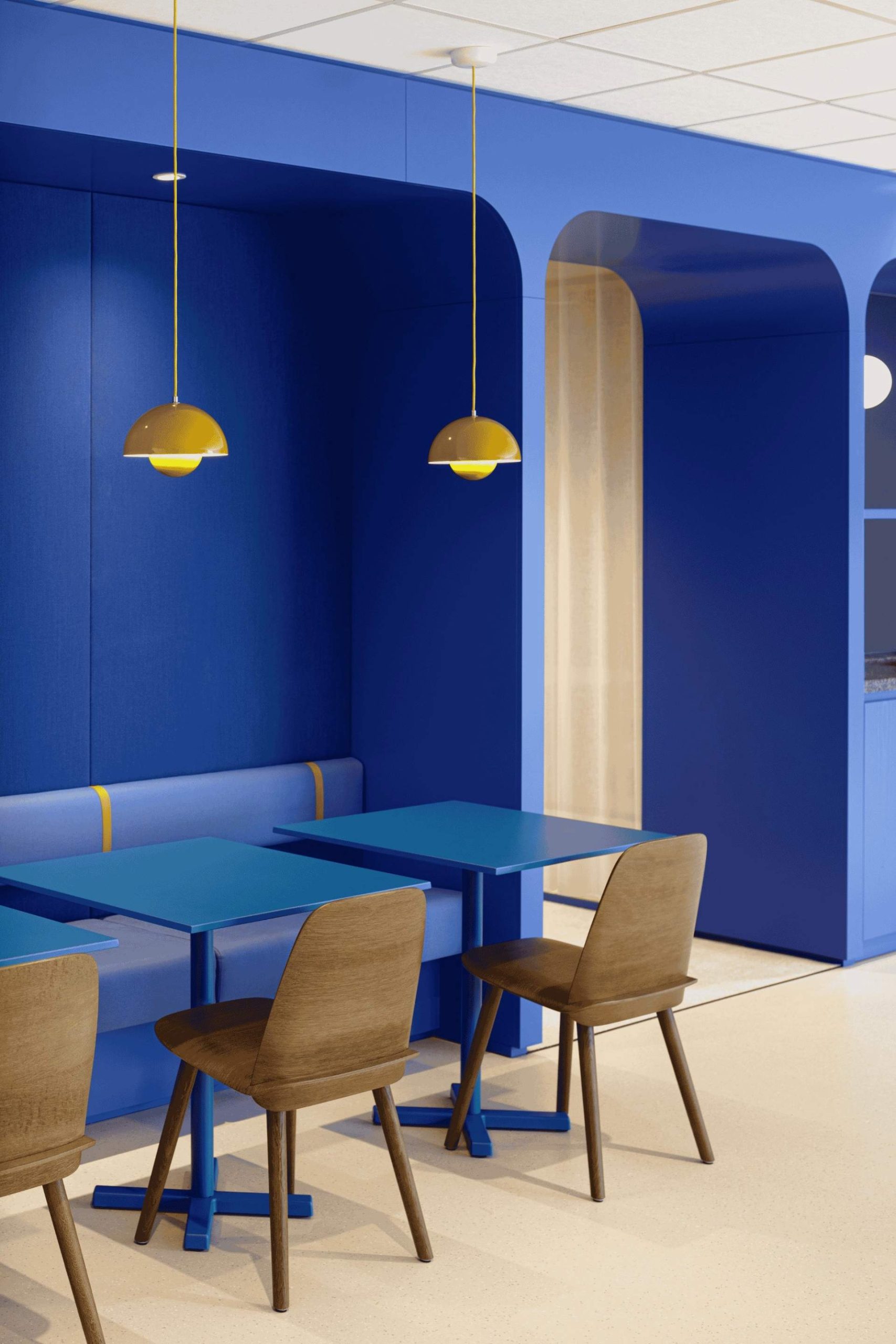 Mur bleu, tables pour déjeuner et banquettes assorties au mur, chaises en bois, luminaires suspendus jaune
