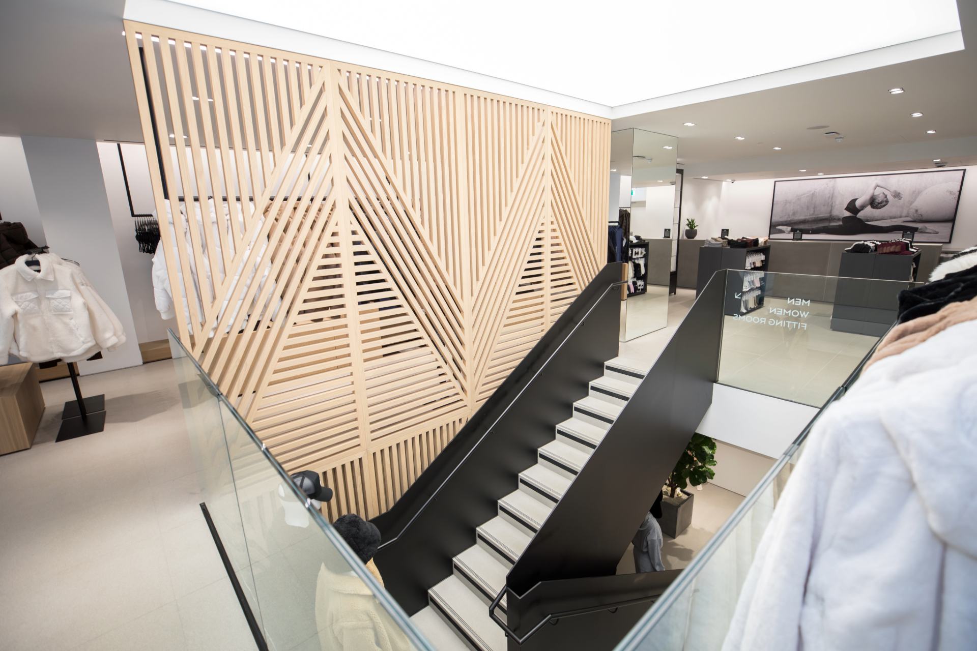 Photo de l'escalier menant à l'étage inférieur avec la structure décorative en bois