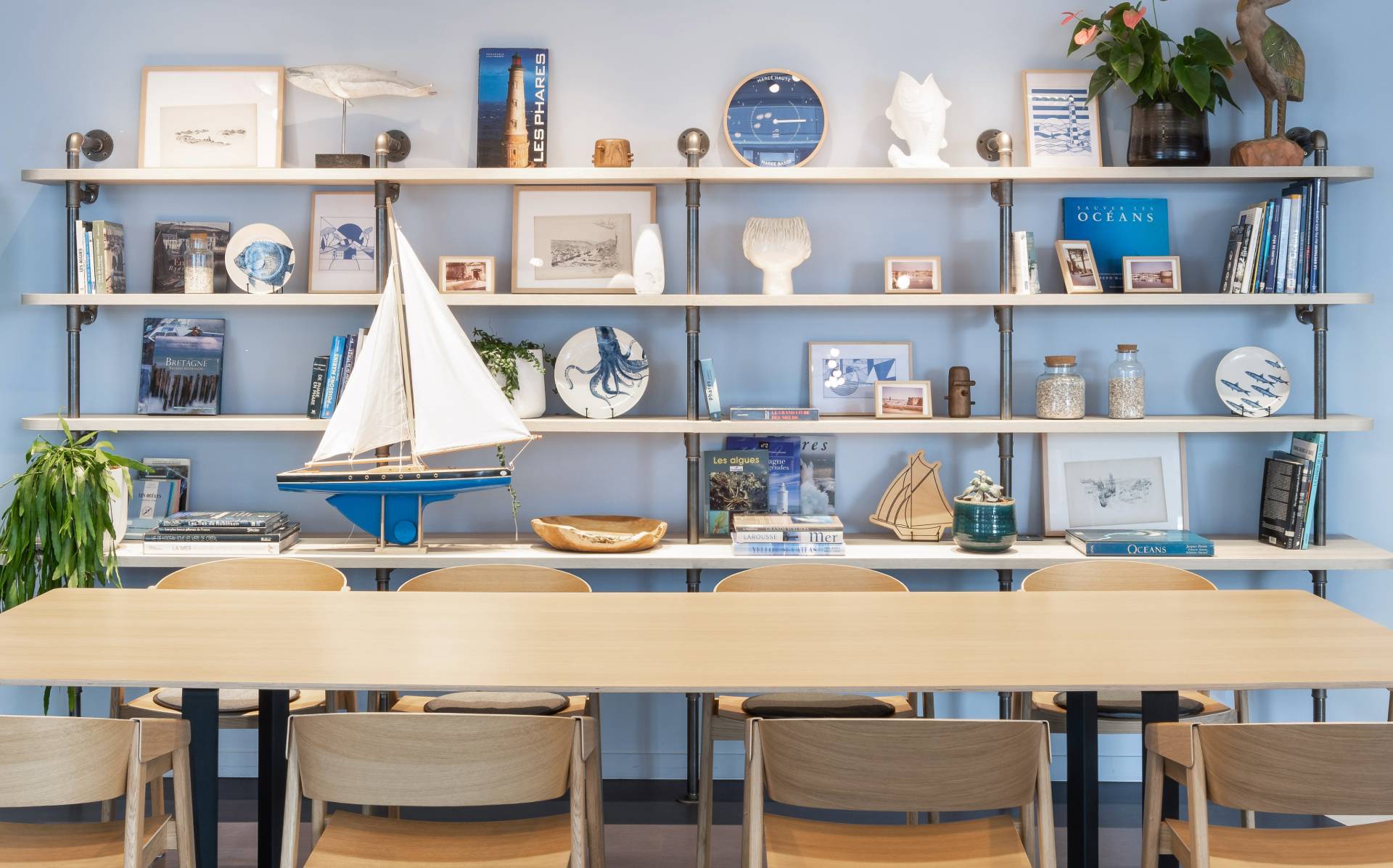 Salle de réunion avec grande étagère avec des décoration bleu et blanche autour du thème de la mer
