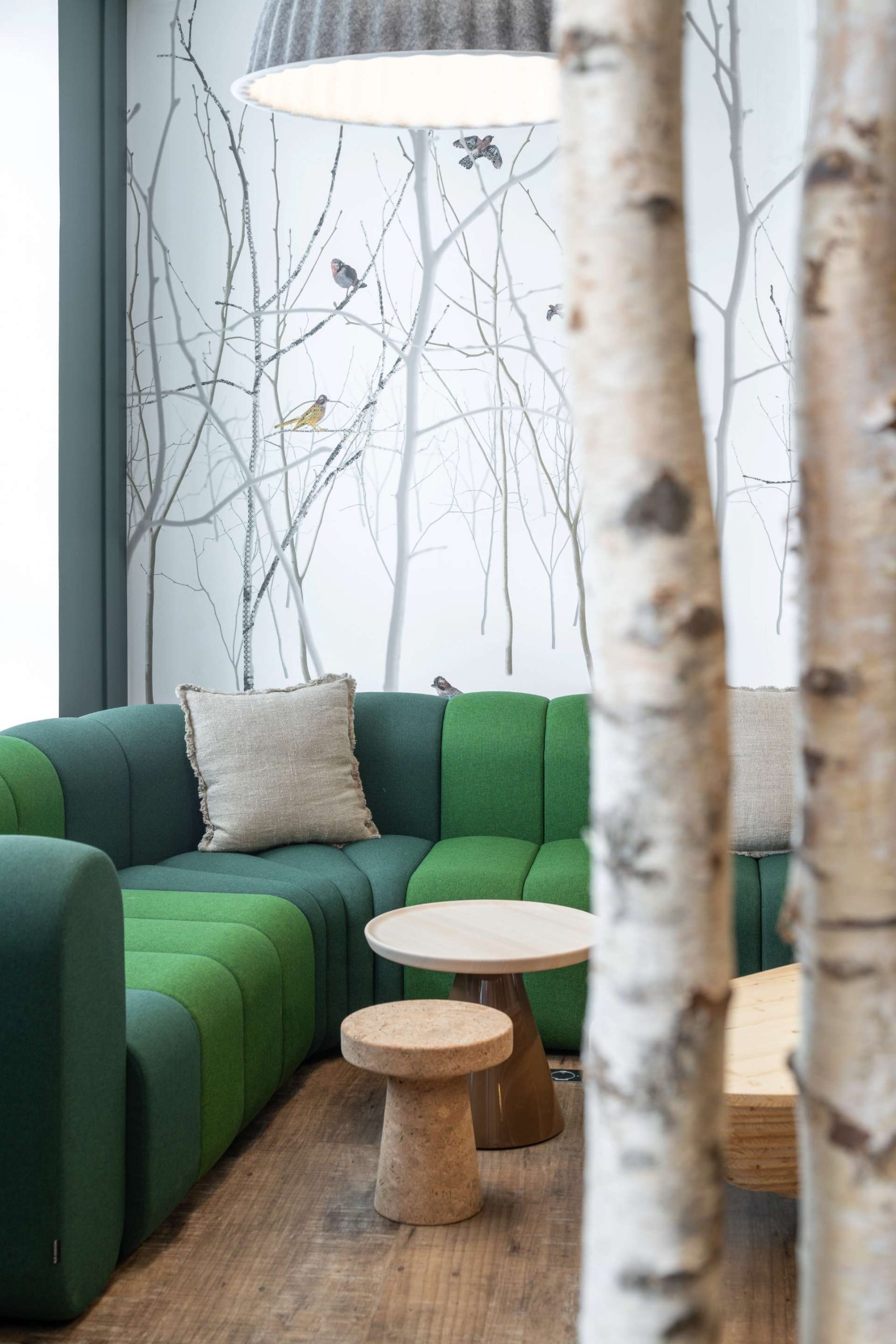 Salon avec grand canapé d'angle vert et table basse en bois