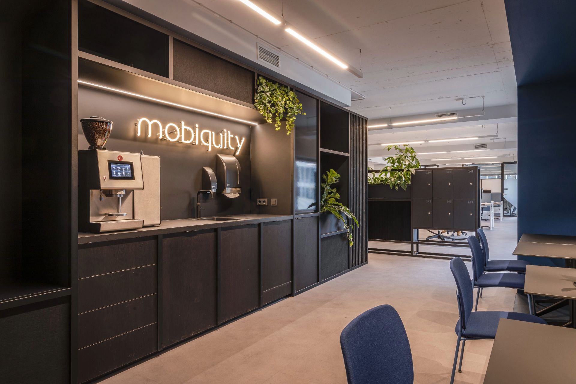 Cafétéria, meubles noirs avec le logo Mobiquity en néon blanc