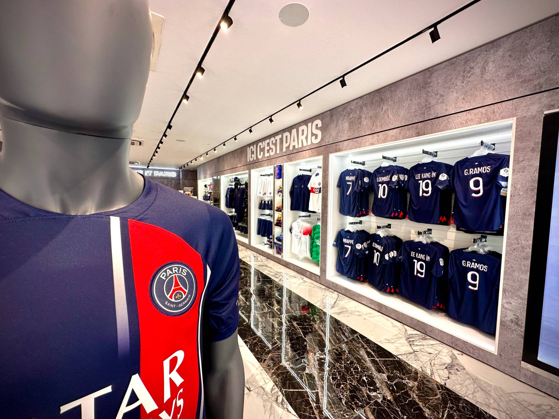 Vu des présentoirs avec les t-shirt et la phrase du PSG "Ici c'est Paris" au dessus