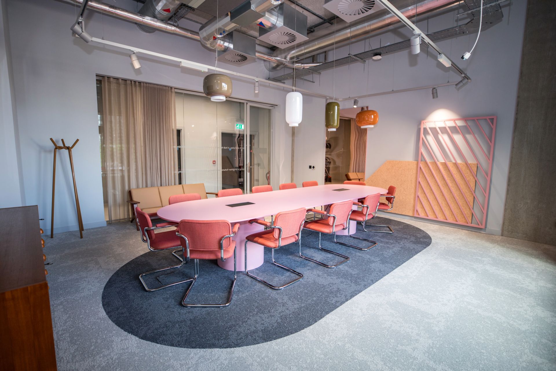 Salle de réunion avec tables et chaises oranges - The Social Hub
