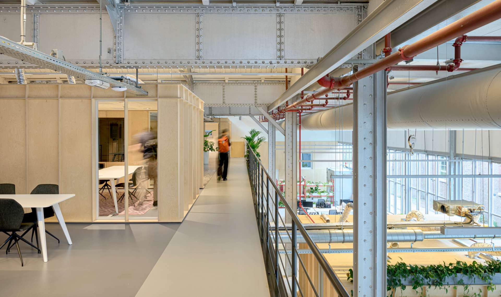 Vue de l'étage, salle de réunion dans un box en bois clair, étage inférieur visible