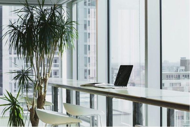 Photo décorative article de blog - Espace de coworking avec tables hautes donnant sur des baies vitrées