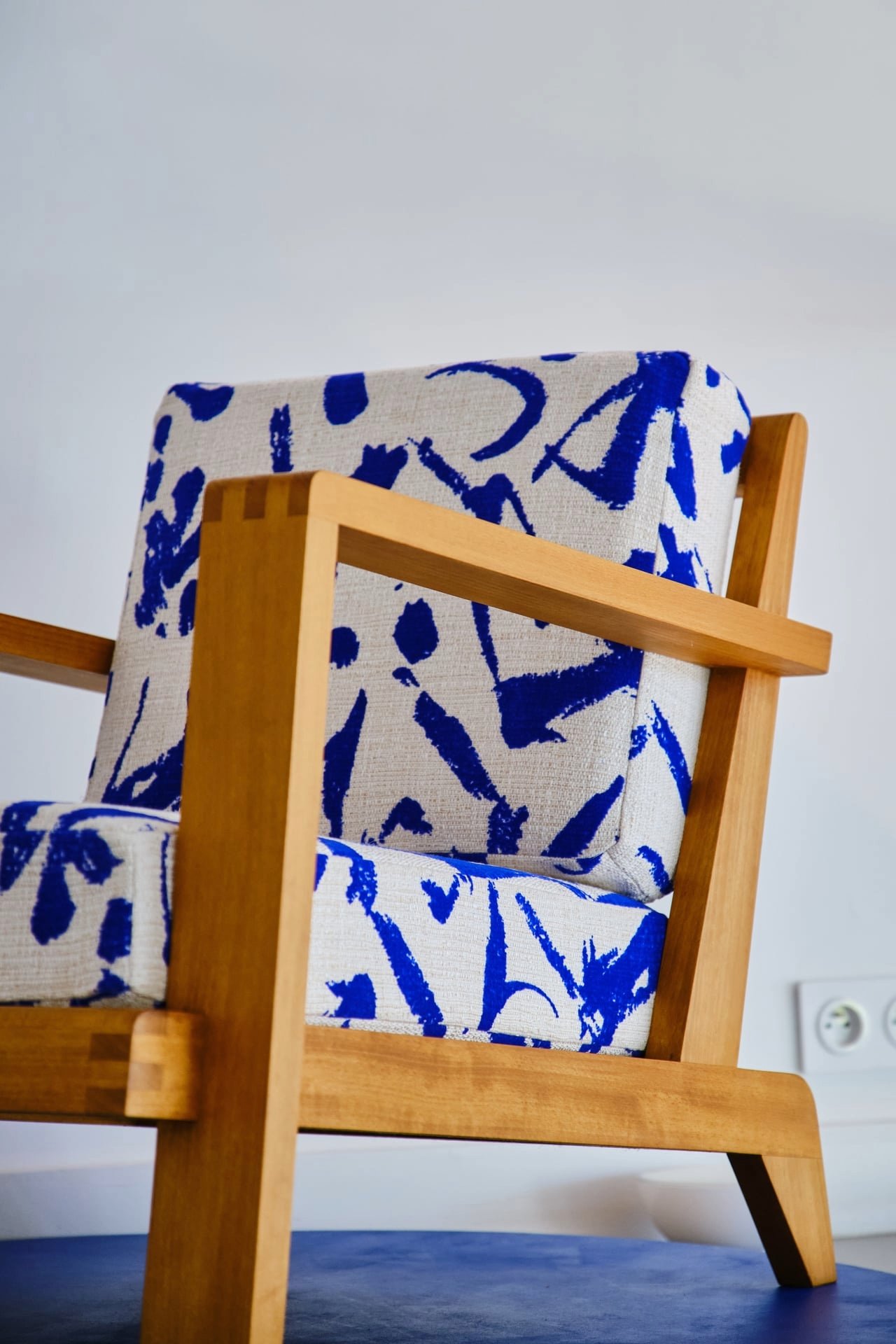 fauteuil en bois clair avec tissu blanc et bleu