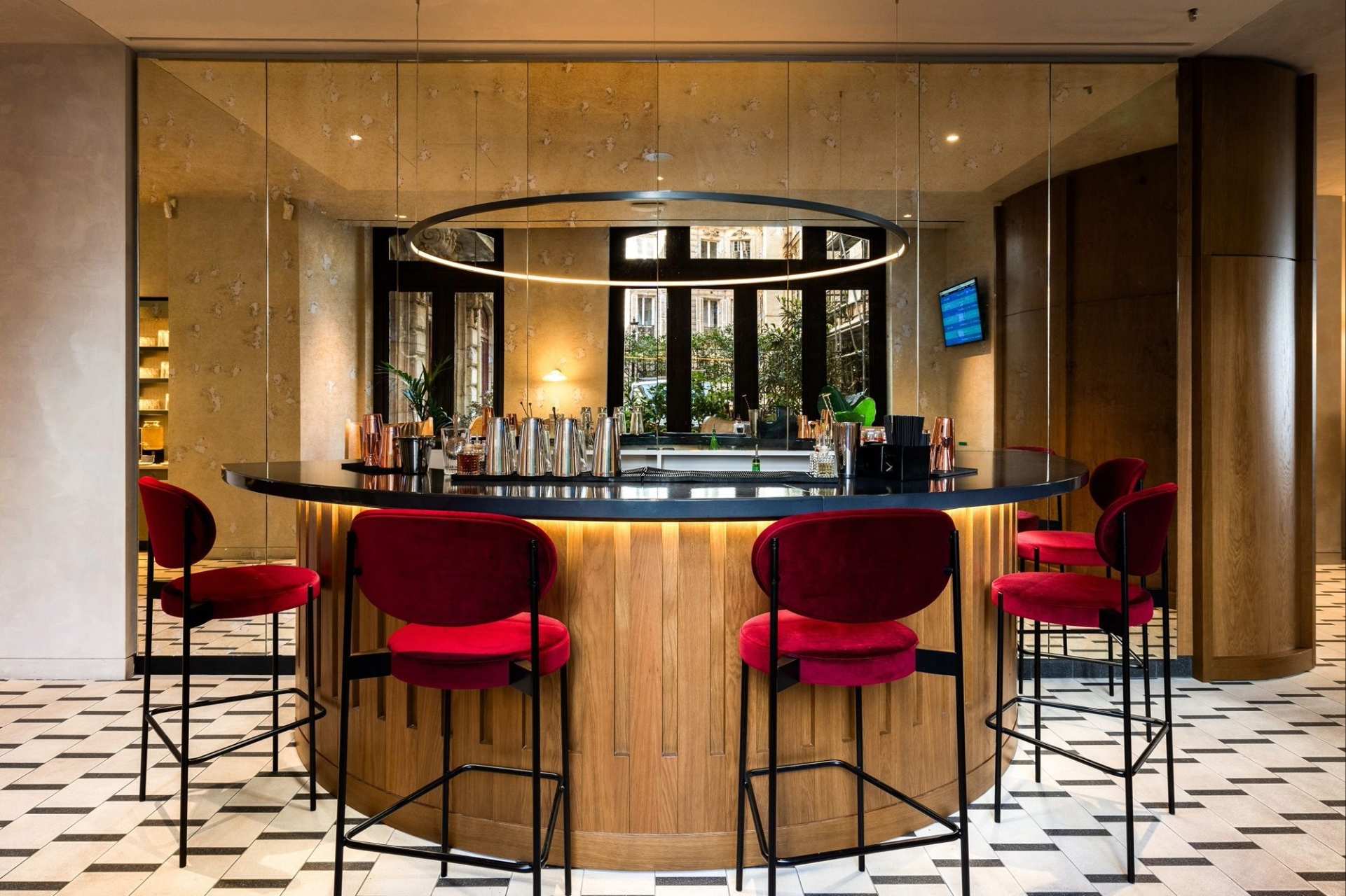 Vu du bar en bois marron, siège en hauteur métallique coussin rouge