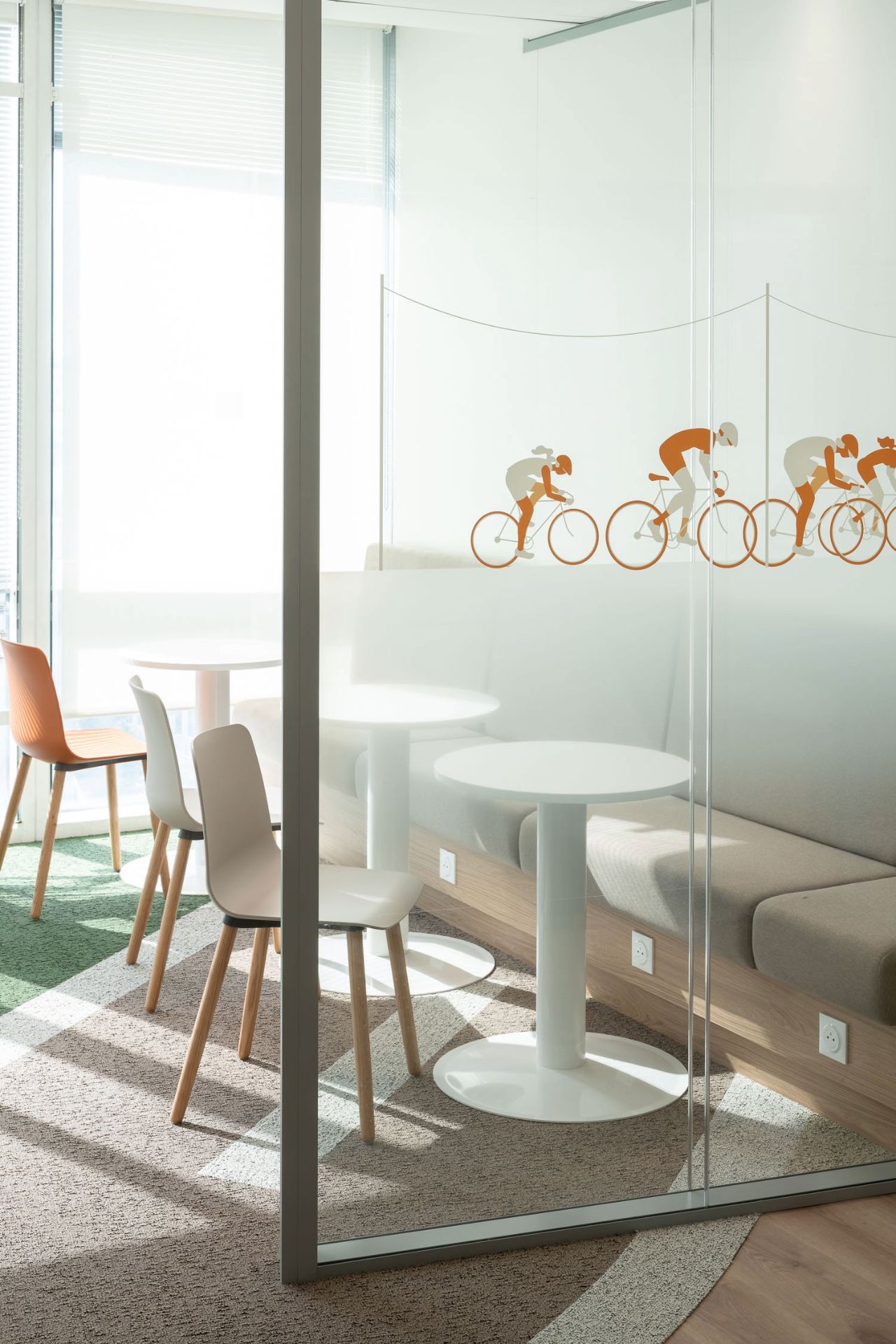 Photo d'une vitrophanie représentant des cyclistes orange.