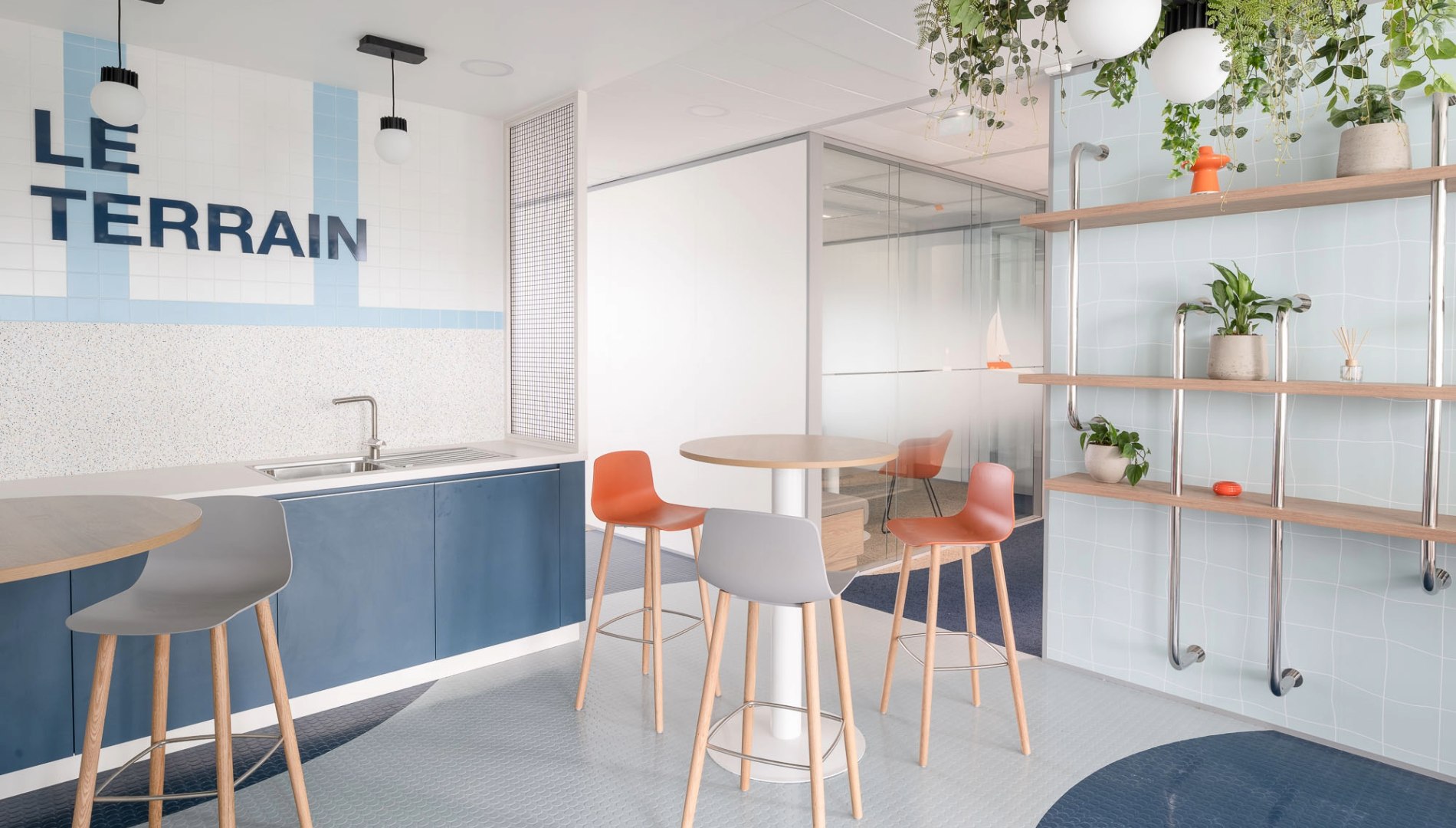 Photo d'une salle de convivialité avec fond bleu et inscription Terrain.