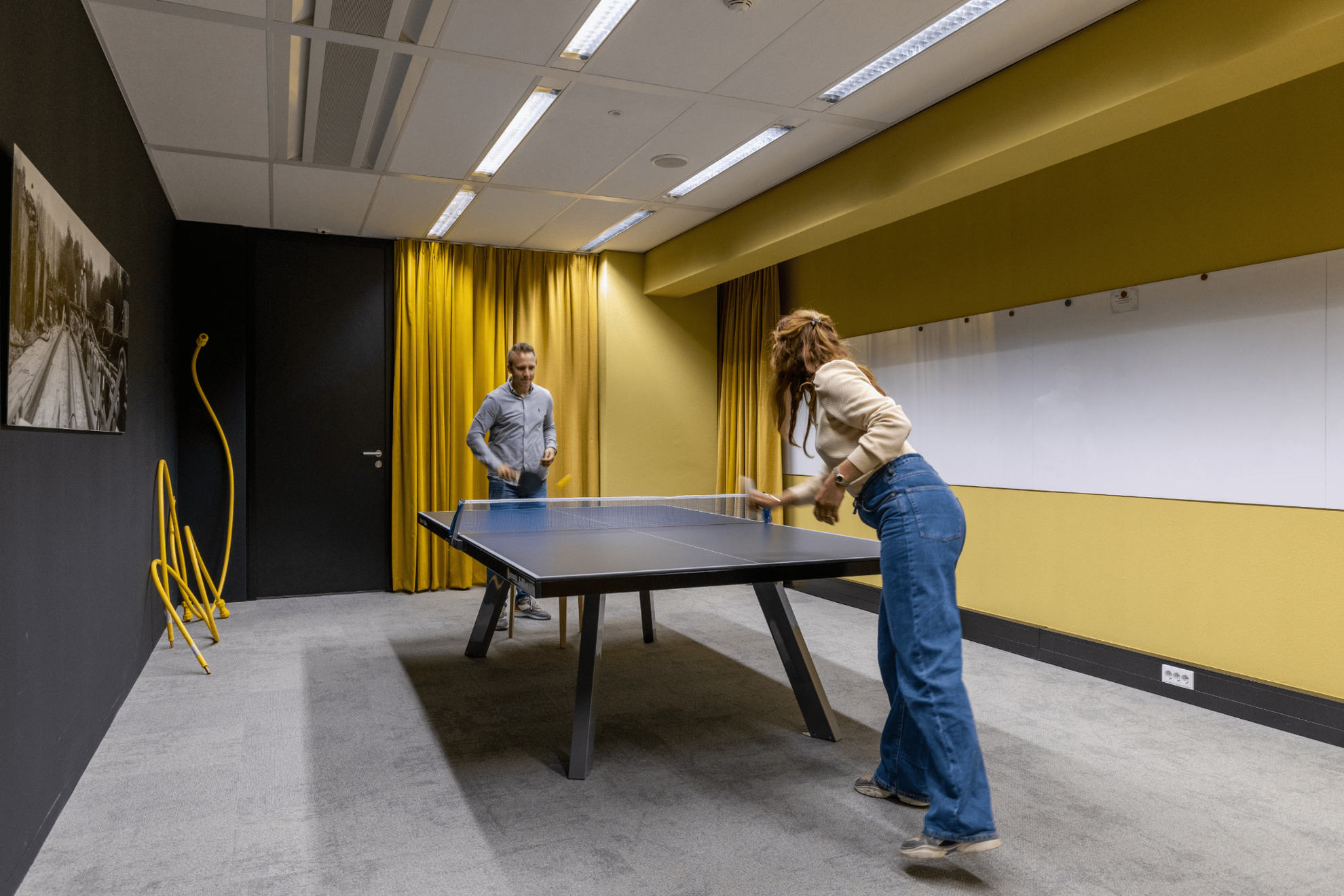 Photo de deux personnes jouant au ping pong.