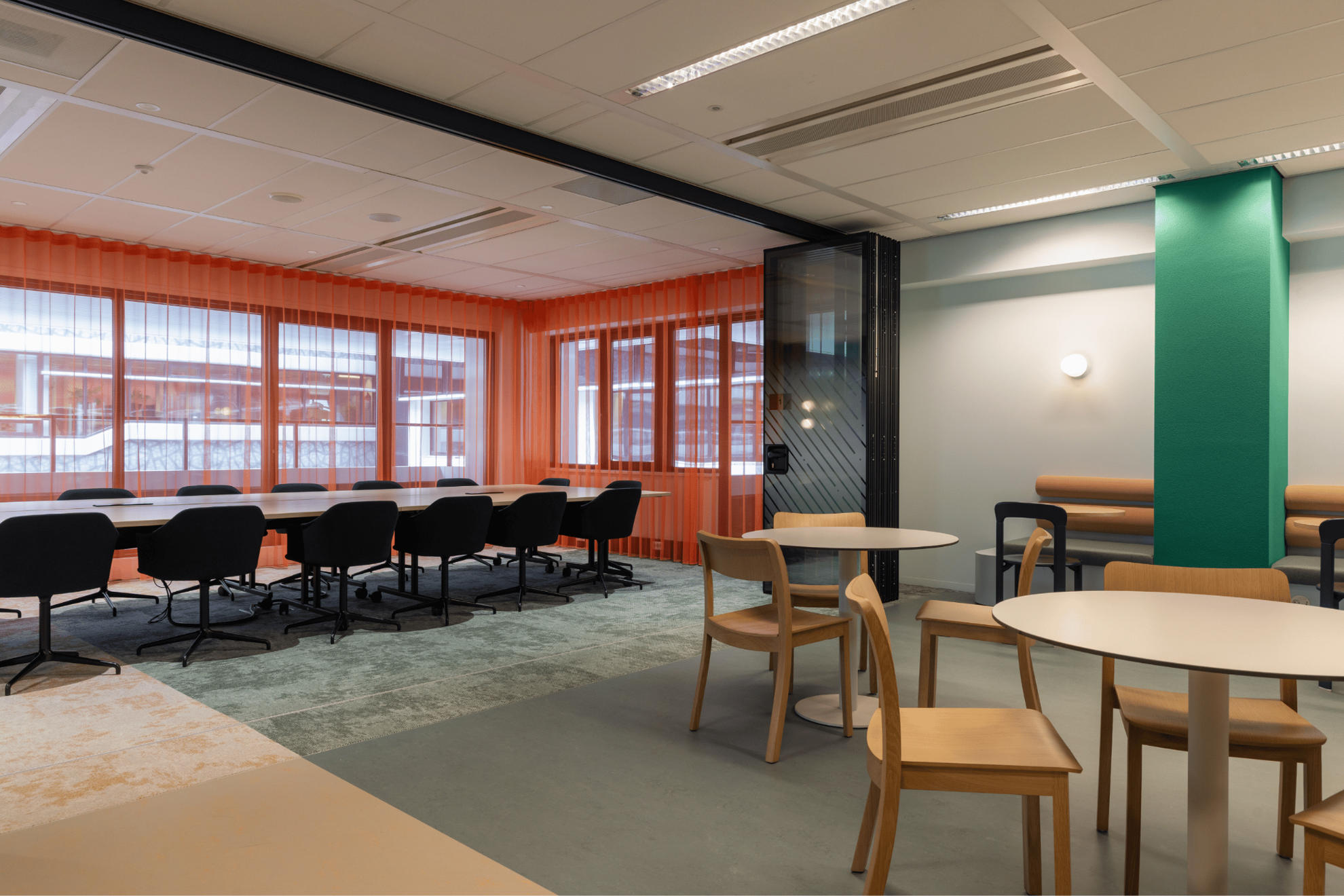 Photo de la salle de réunion centrale au fond avec l'espace de restauration au premier plan à droite avec un séparateur coulissant.