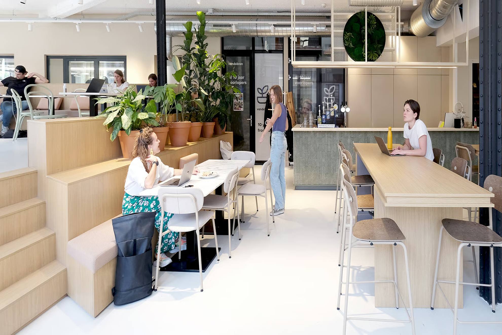 Espace de restauration avec la cafet, des chaises et des salariés.