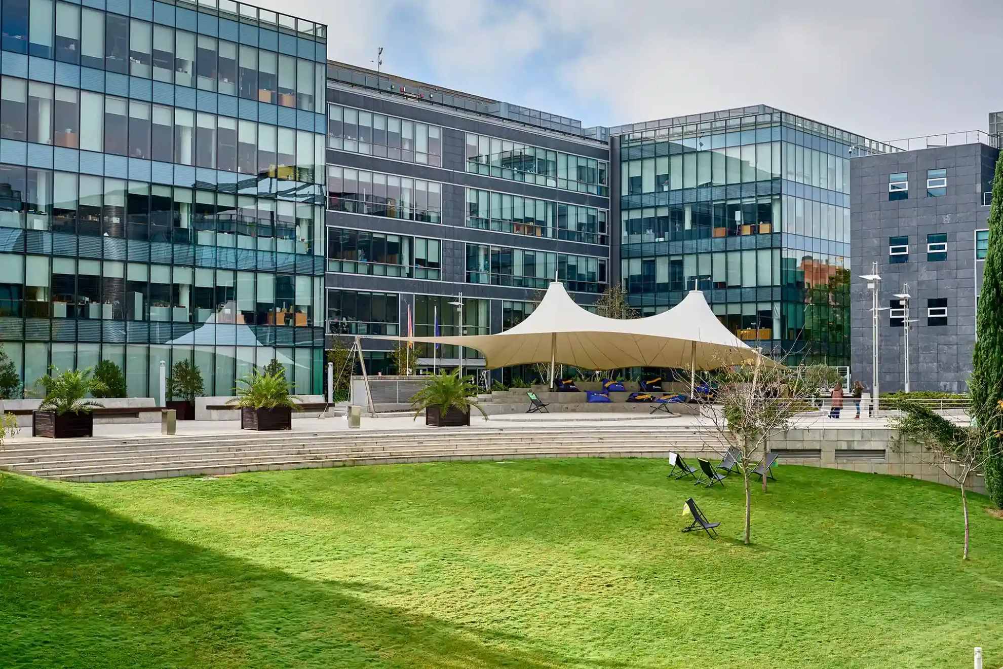 Vue de l'extérieur du bâtiment avec un chapiteau et une pelouse à l'avant.
