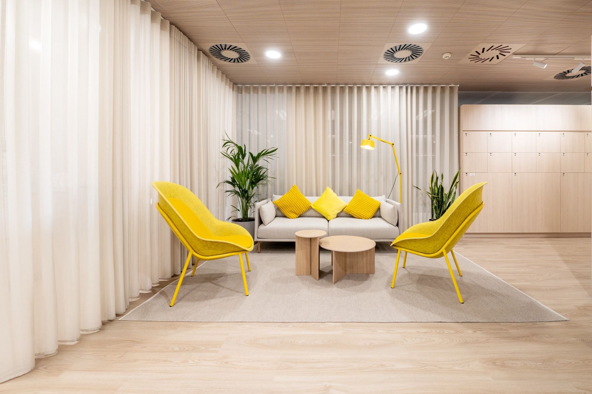 Un canapé avec deux chaises jaunes et une table en forme de buche.