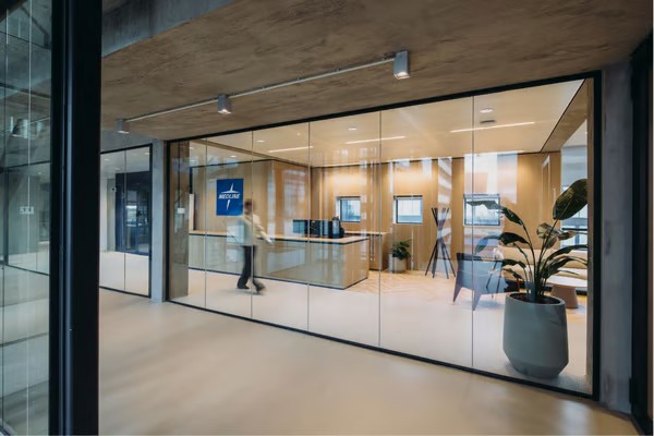 Accueil de Medline avec le logo en bleu, un comptoir en coin avec des canapés et tables de basse plus une plante et une personne en blanc marchant.