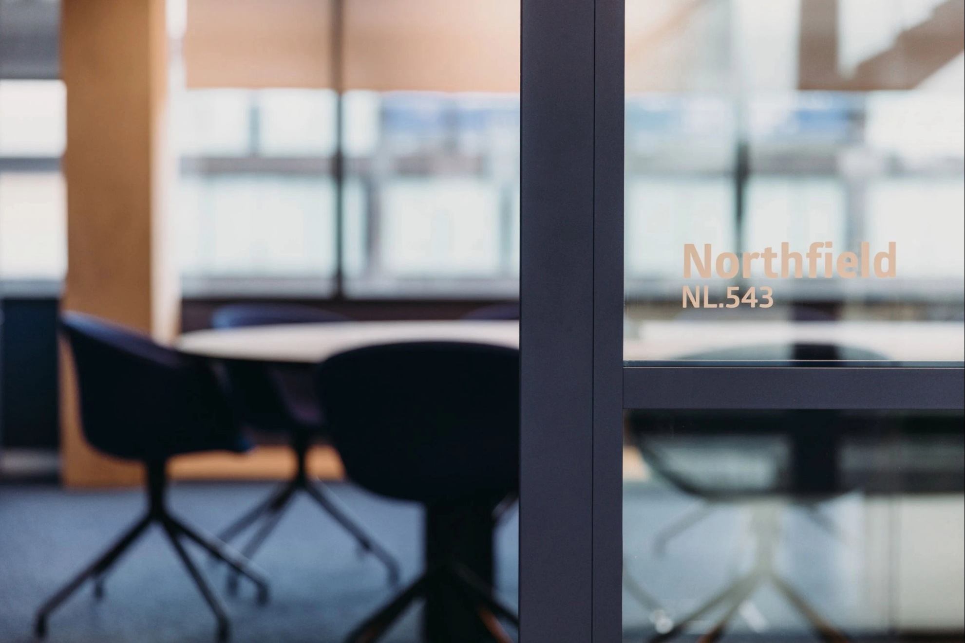Salle de réunion avec un flou en arrière-plan et au premier plan sur la vitre l'inscription Northfield NL.543.