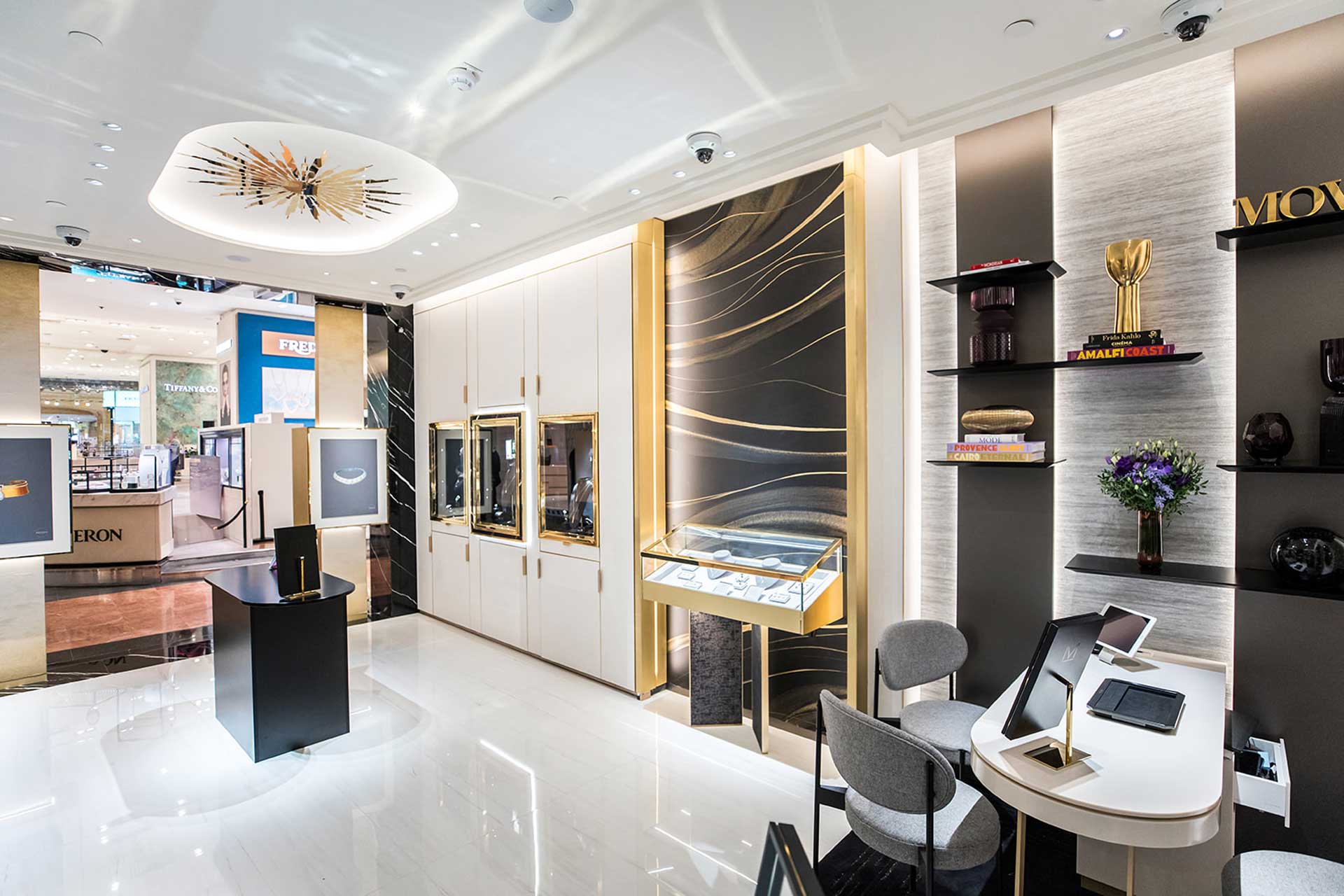 Une vue latérale montrant l'ouverture de la boutique sur le centre commercial avec des affiches publicitaires lumineuses à l'entrée.