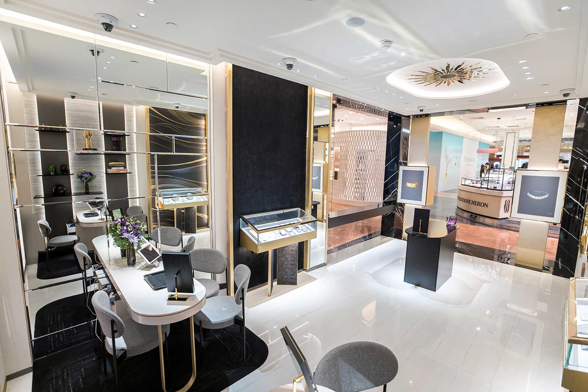 Une perspective depuis l'espace salon montrant le jeu de miroirs muraux qui agrandissent l'espace et reflètent la luminosité du magasin.