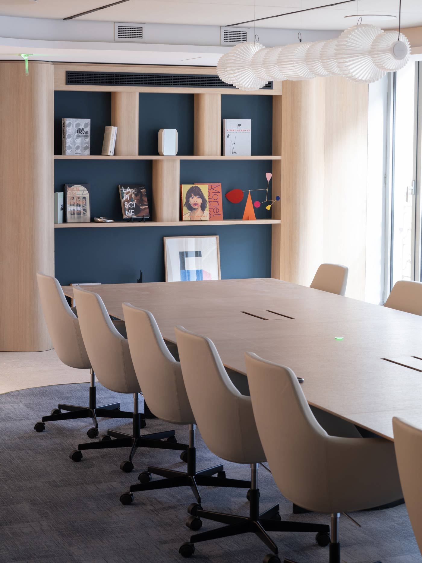 Une perspective mettant l'accent sur l'alignement des fauteuils et l'ambiance feutrée de cet espace de travail.